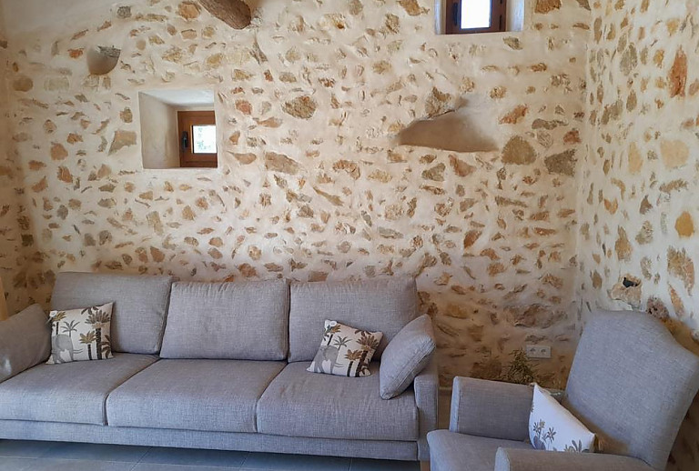 Wohnzimmer mit Natursteinwand und Couch