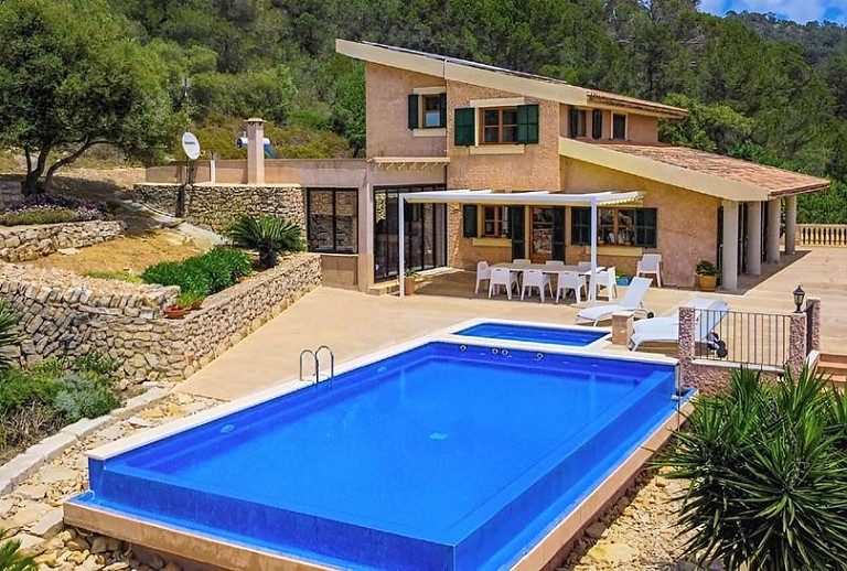 Poolbereich mit Sonnenliegen vor der Finca