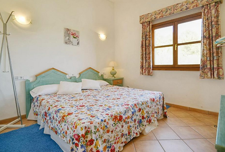 Schlafzimmer mit Doppelbett und Kleiderständer