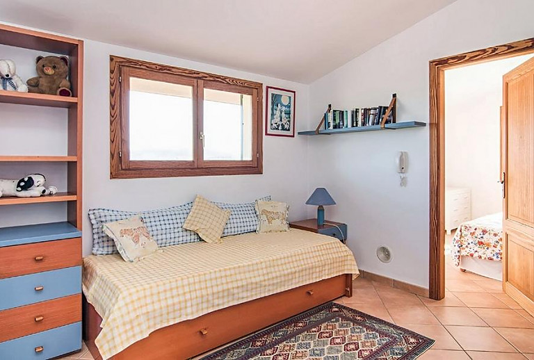 Schlafzimmer mit Einzelbett und Bücherregal