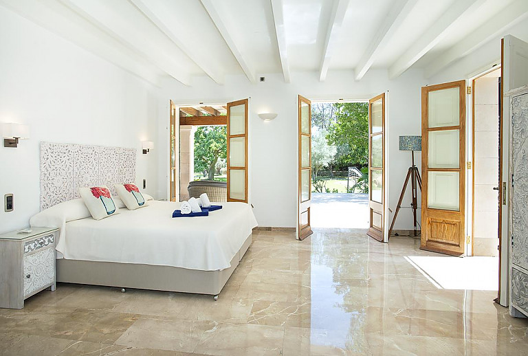 Schlafzimmer mit Doppelbett und Zugang zur Terrasse