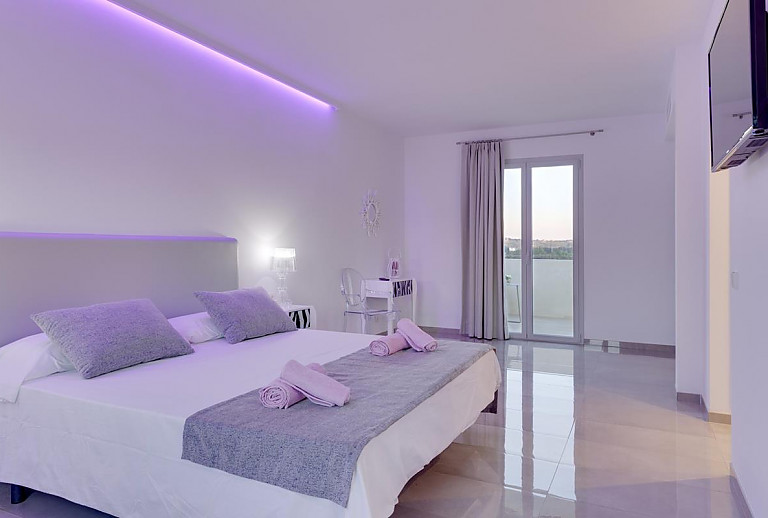 Schlafzimmer mit Doppelbett und Fernseher