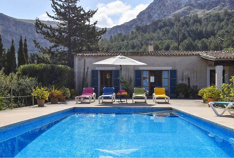 Poolbereich mit Sonnenliegen und Bergblick
