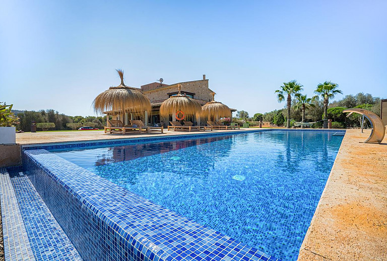 Poolbereich mit Sonnenliegen vor der Finca
