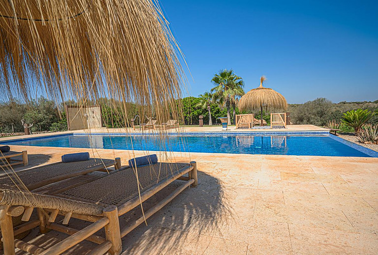 Sonnenschirm mit Sonnenliegen am Pool