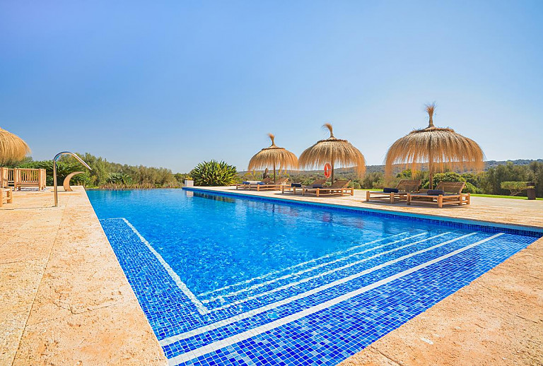 Poolliegen und Sonnenschirme am Poolbreich