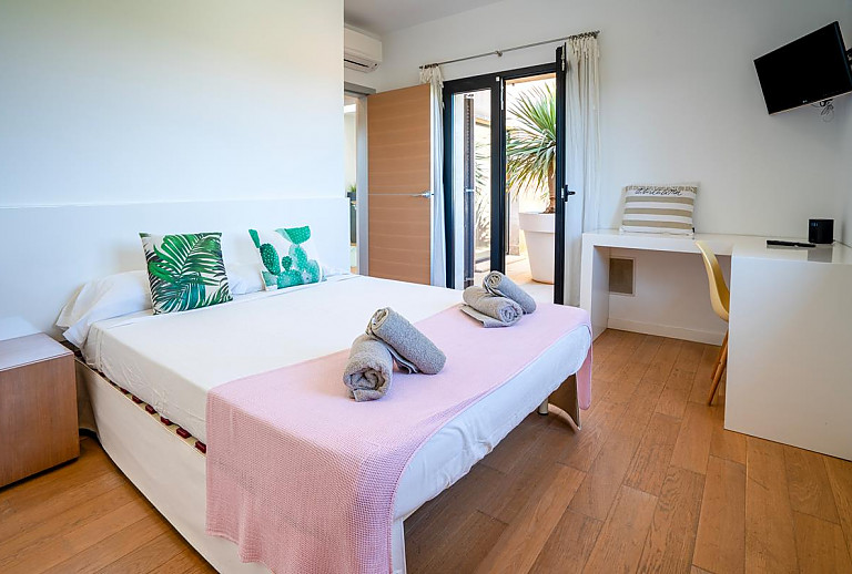 Schlafzimmer mit Doppelbett und Schreibtisch