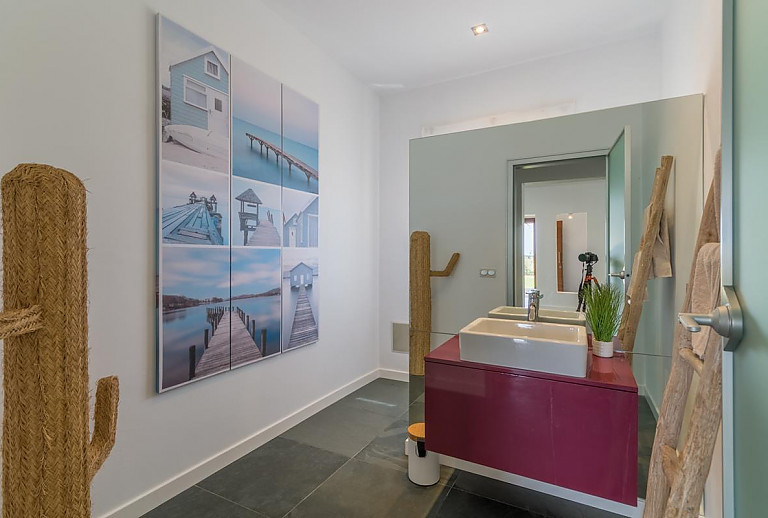 Badezimmer mit Spiegel und Waschbecken