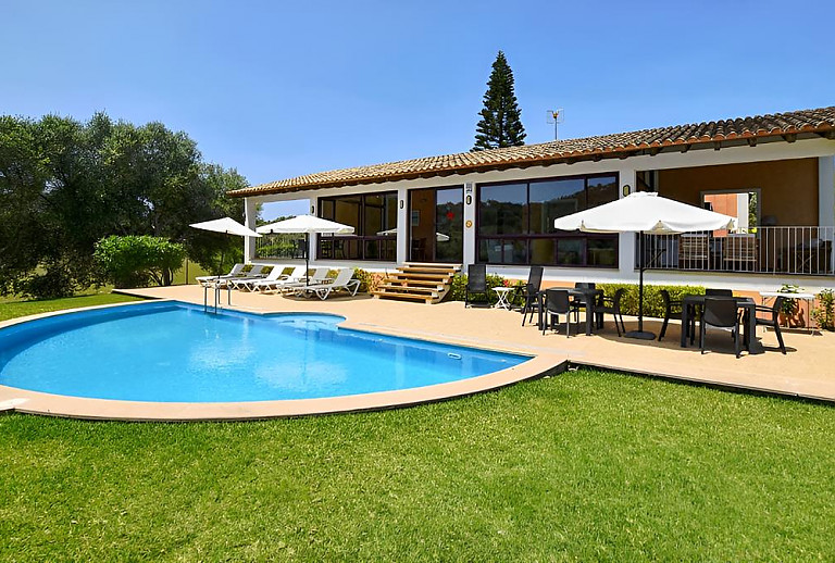 Poolterrasse mit Sonnenliegen vor dem Ferienhaus