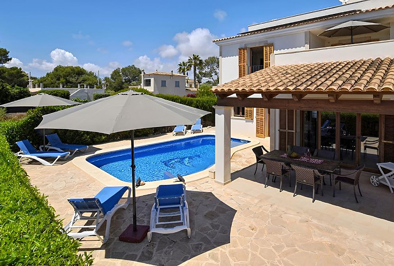 Poolterrasse mit Sonnenschirm und Poolliegen