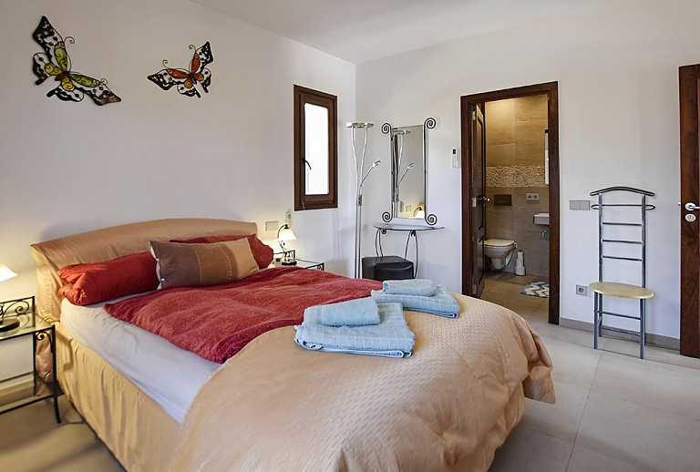 Schlafzimmer mit Doppelbett und Badezimmer