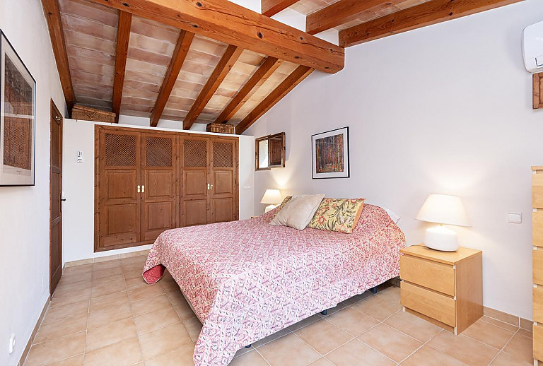 Schlafzimmer mit Doppelbett und Kleiderschrank