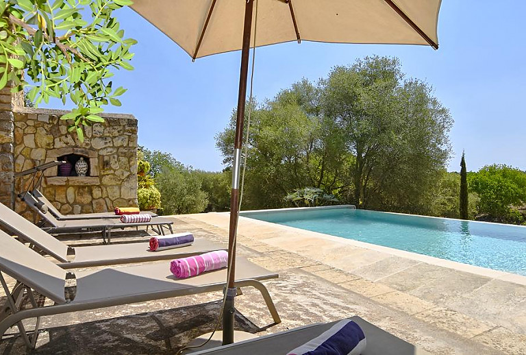 Pool mit Sonnenliegen und Sonnenschirm