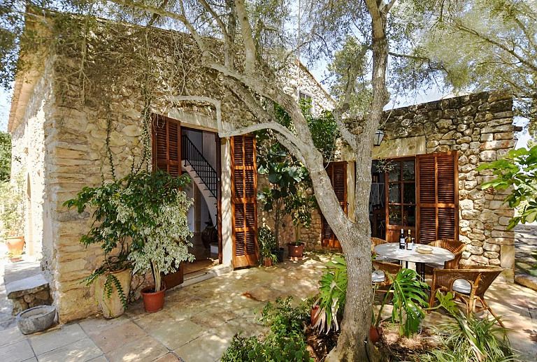 Terrasse im Schatten der Bäume und Gartenmöbeln