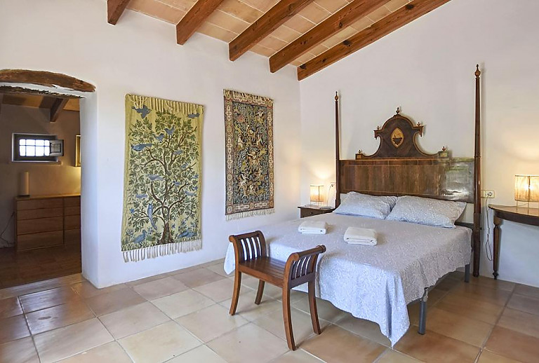 Schlafzimmer mit Doppelbett und Wandteppichen