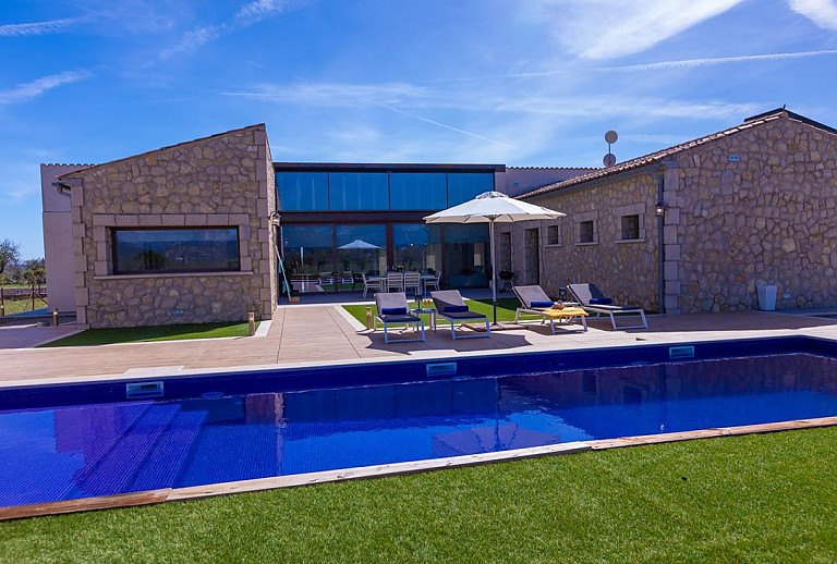 Poolterrasse mit Rasen vor der Finca