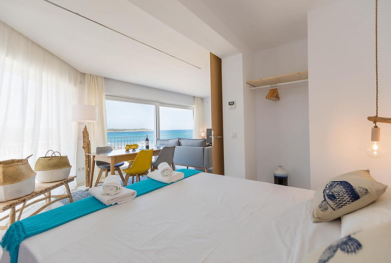 Schlafzimmer mit Doppelbett und Blick ins Wohnzimmer