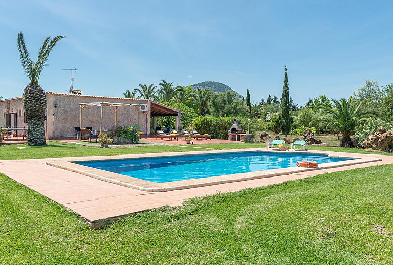 Garten mit Rasen und Pool vor der Finca