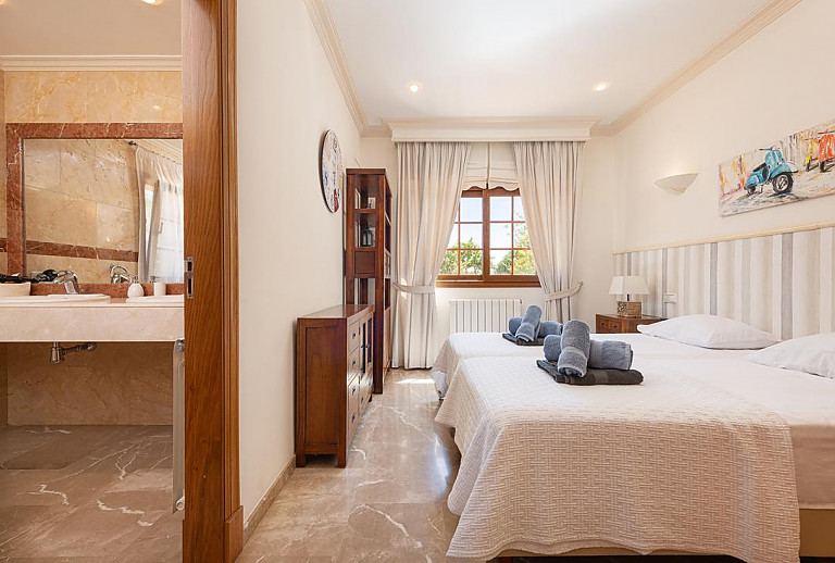 Schlafzimmer mit Doppelbett und Badezimmer