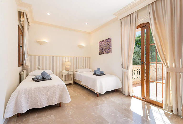 Schlafzimmer mit Einzelbetten und Balkon