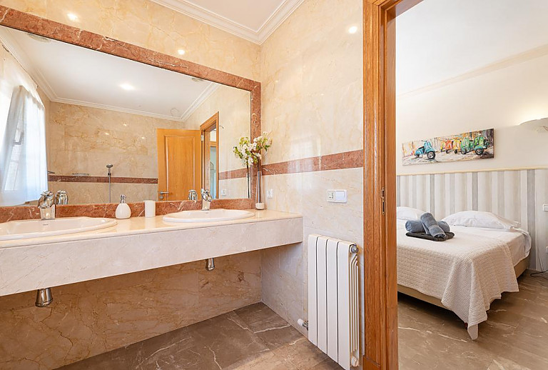 Spiegel und Waschbecken im Bad vor dem Schlafzimmer