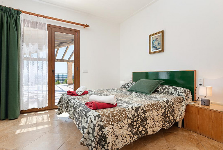 Schlafzimmer mit Doppelbett und Zugang zur Terrasse