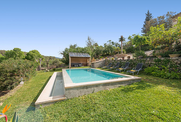 Sonnenliegen auf dem Rasen am Pool