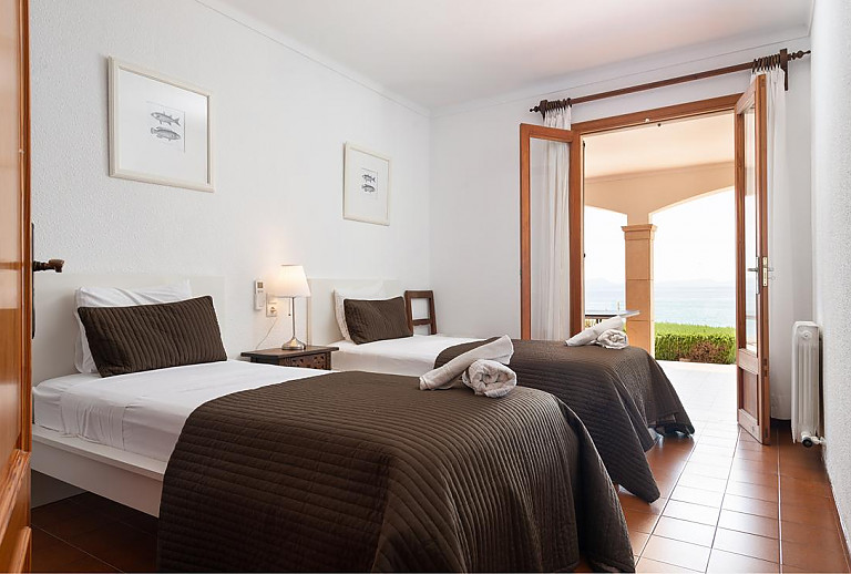 Schlafzimmer mit Einzelbetten und Balkon