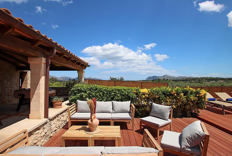 Terrasse mit Sitzmöbeln und Hecke