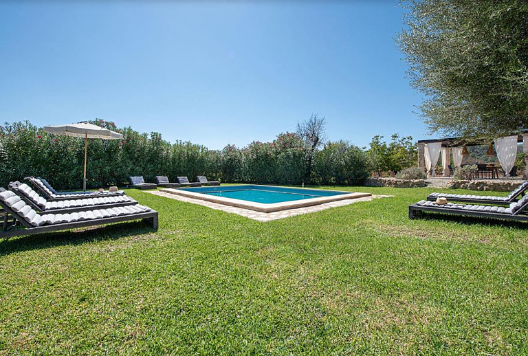 Rasen mit Sonnenliegen am Pool