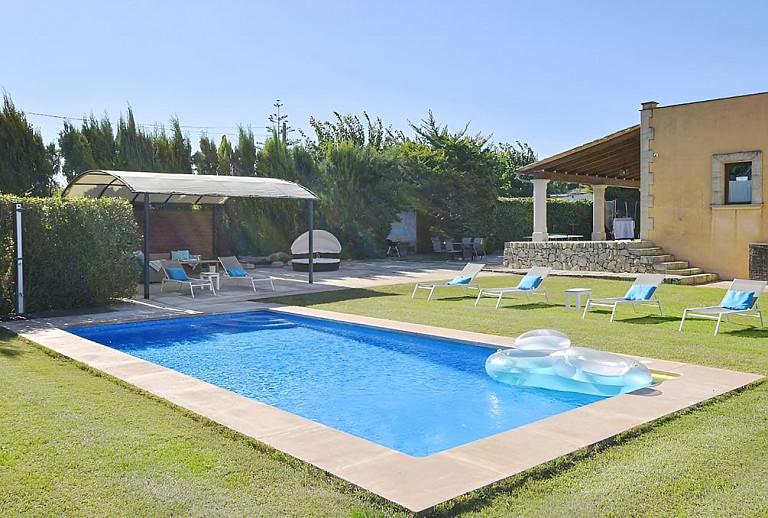 Sonnenliegen und Sonnensegel am Poolbereich