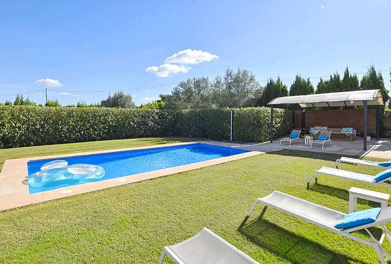 Rasen und Sonnenliegen am Pool