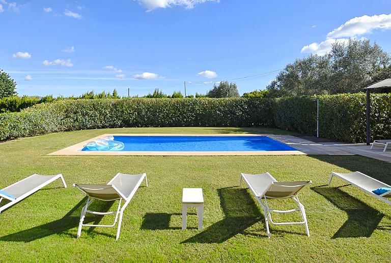 Sonnenliegen und Rasen am Poolbereich