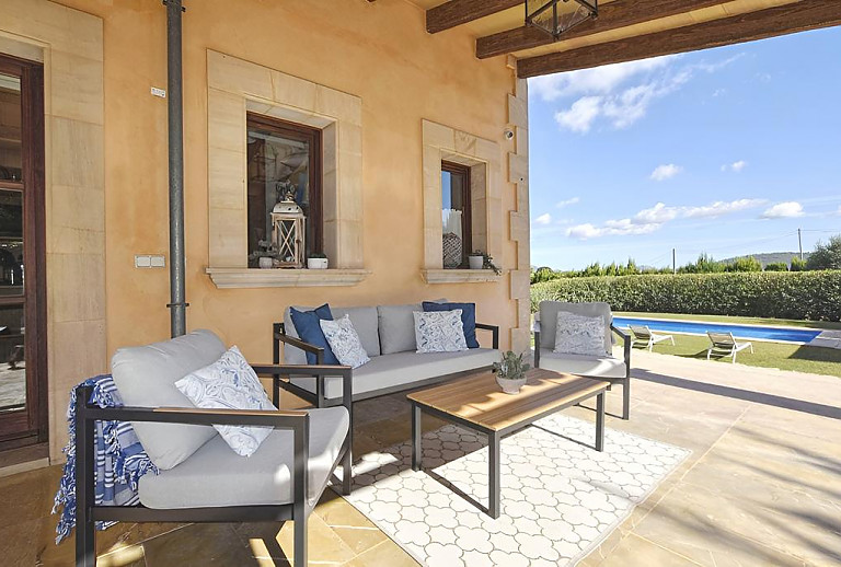 Terrasse mit Poolblick und Gartenmöbeln