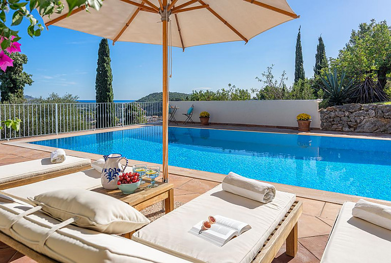 Sonnenliegen und Sonnenschirm am Poolbereich