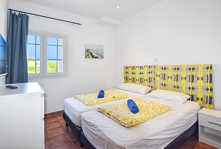 Schlafzimmer mit Einzelbetten und Fernseher