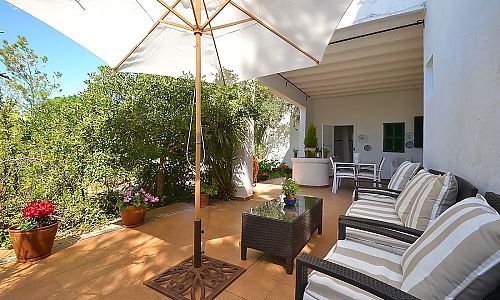 Terrasse mit Topfpflanzen und Gartenmöbeln