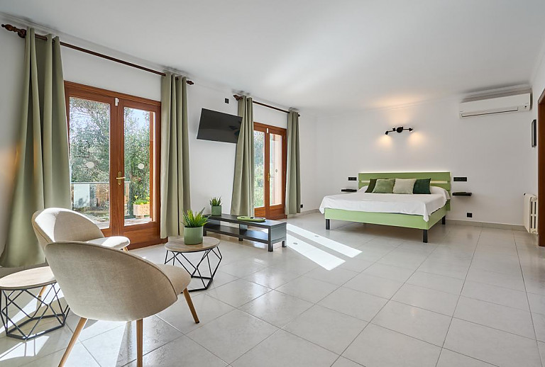 Schlafzimmer mit Doppelbett und Fernseher