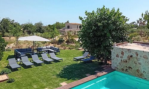Sonnenliegen am Pool auf dem Rasen im Garten