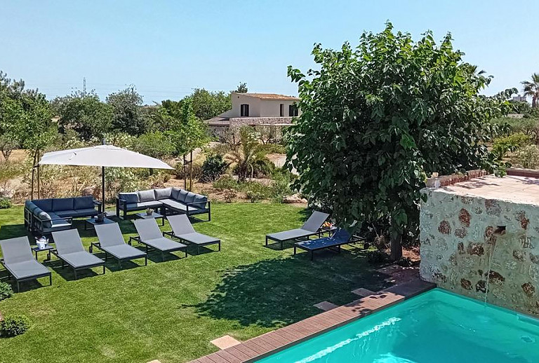 Sonnenliegen am Pool auf dem Rasen im Garten
