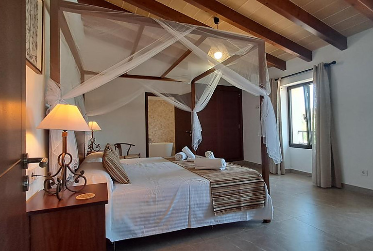 Schlafzimmer mit Doppelbett und Badezimmer