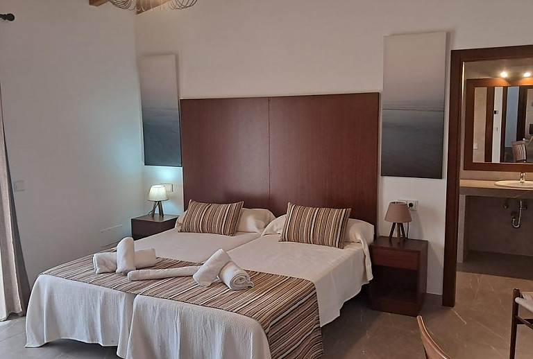 Schlafzimmer mit Einzelbetten und Bad