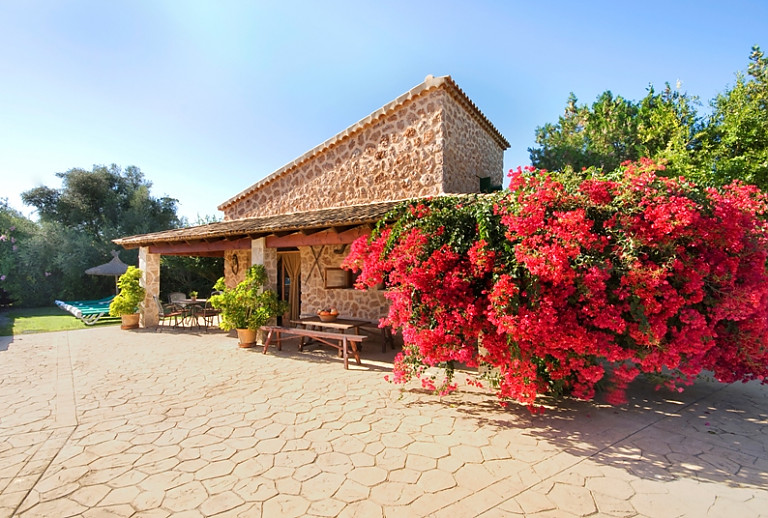 Finca Natursteinfassade Blumen Büsche